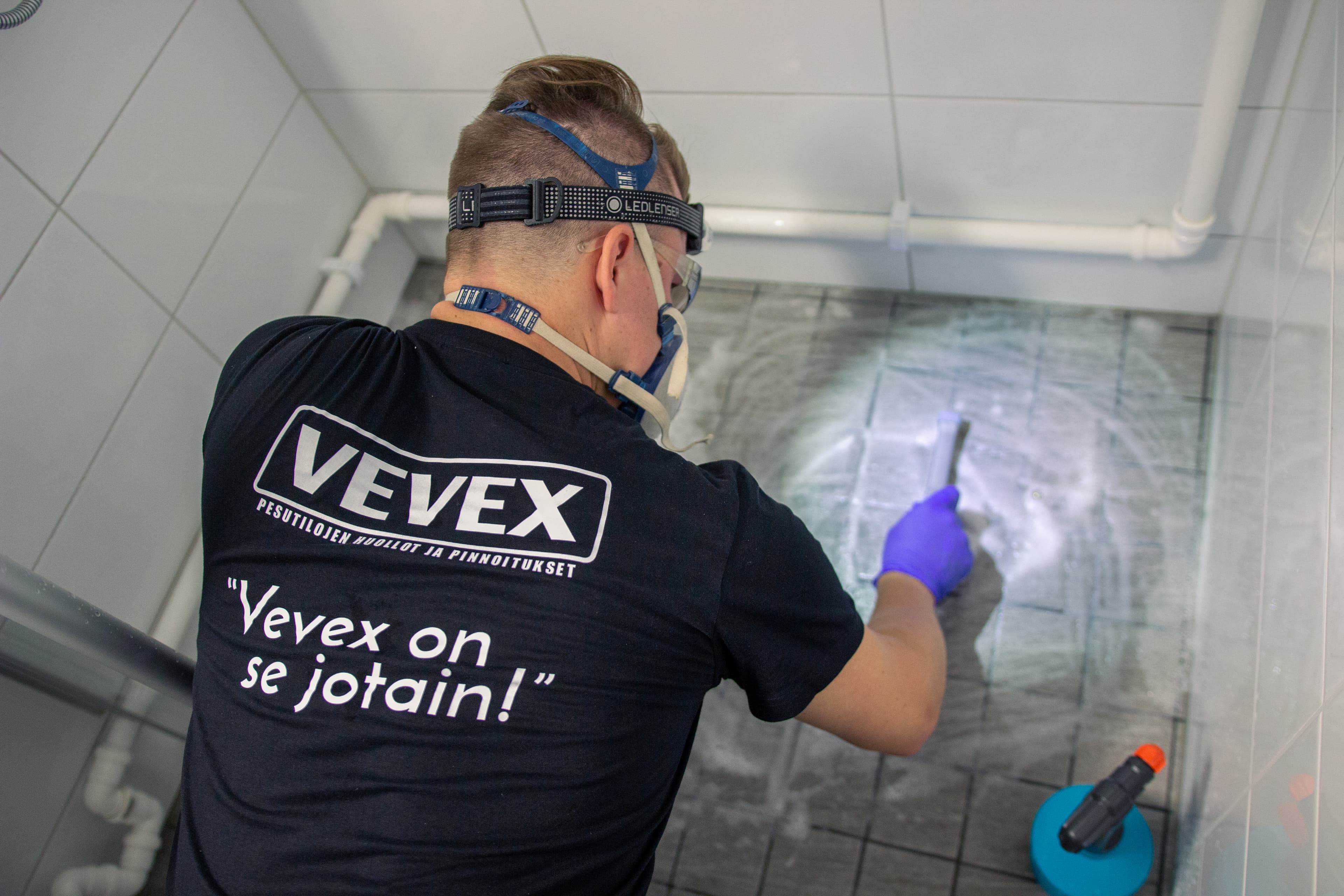Vevex installer wearing a respirator maintaining a bathroom tile surface